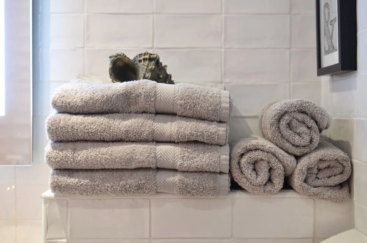 A stack of towels in a light filled bathroom