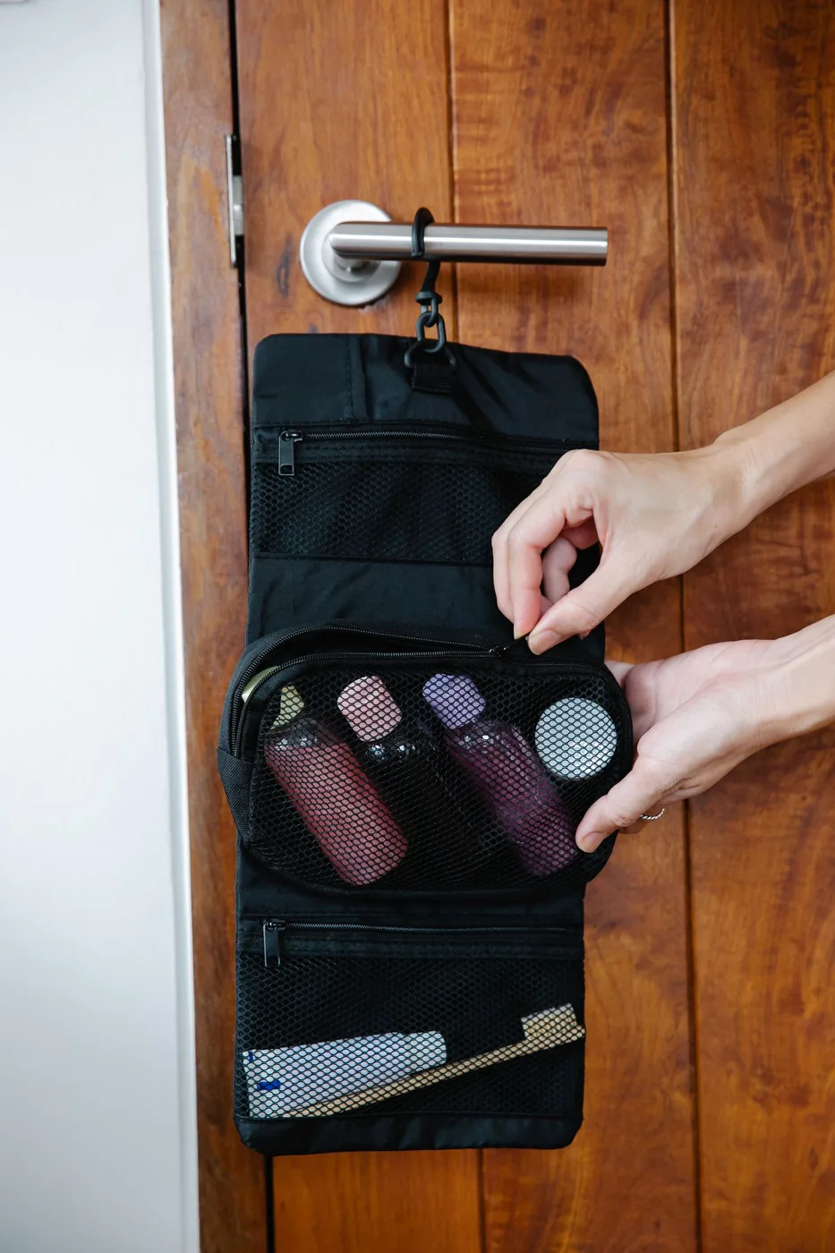 A toiletry bag being zipped around personal care essentials